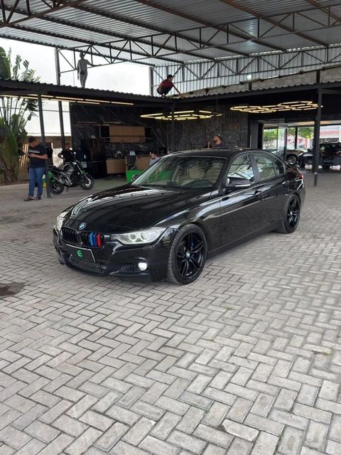 BMW 320i na cor preta, vista dianteira em três quartos (foto 2 de 17)