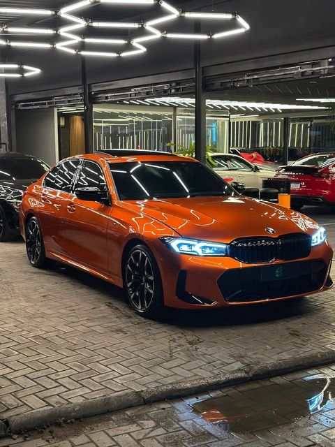 BMW 320i com envelopamento laranja, vista dianteira em três quartos (foto 2 de 20)