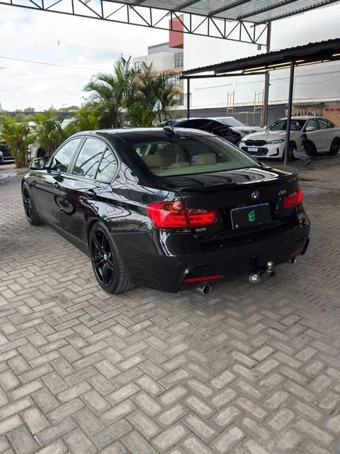 BMW 320i na cor preta, vista traseira em três quartos