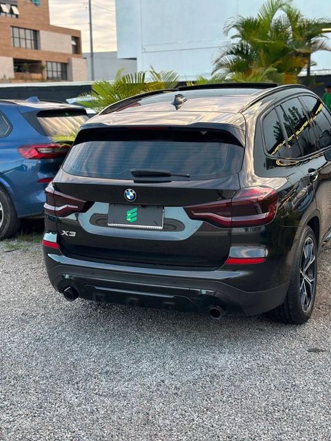 BMW X3 na cor preta, vista traseira em três quartos (foto 5 de 17)