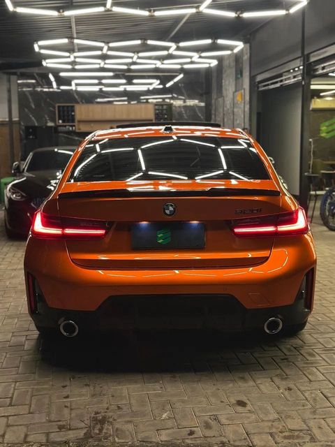 BMW 320i com envelopamento laranja, vista de trás